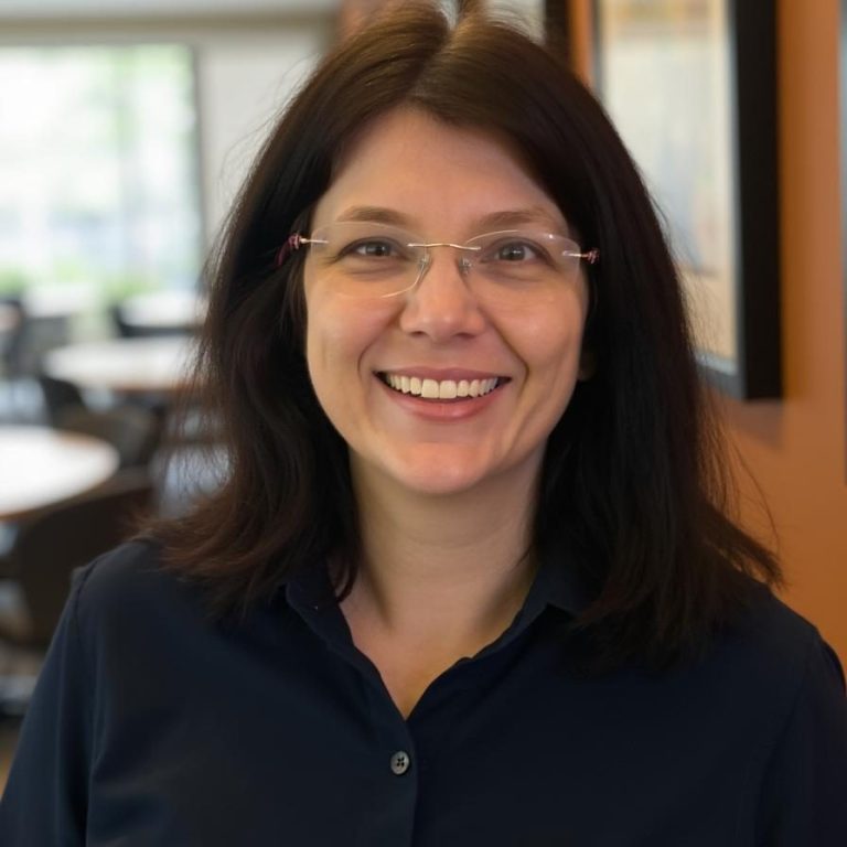 A white woman with brown hair wearing a navy shirt